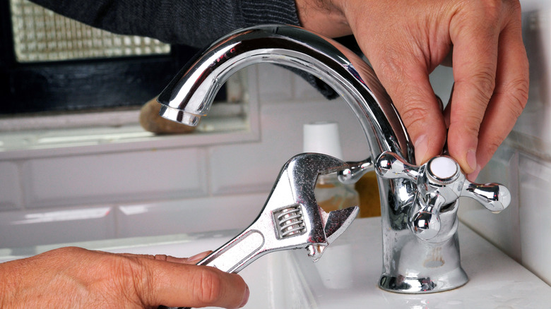 hands fixing the sink