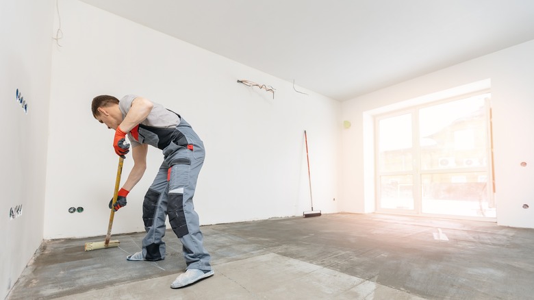 man priming garage floor