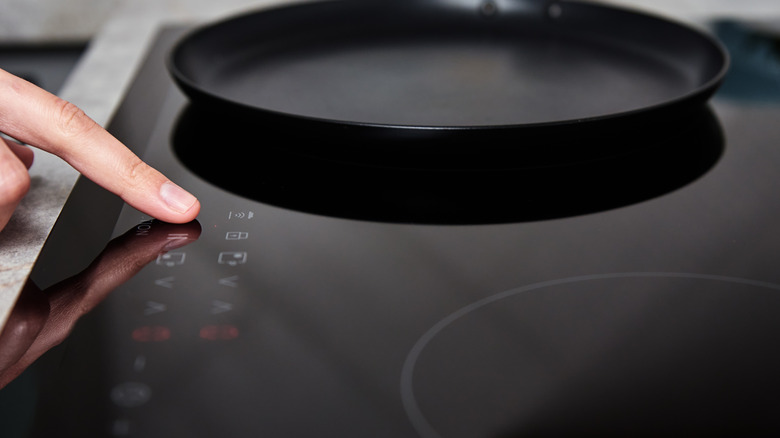 Woman operating induction cooktop