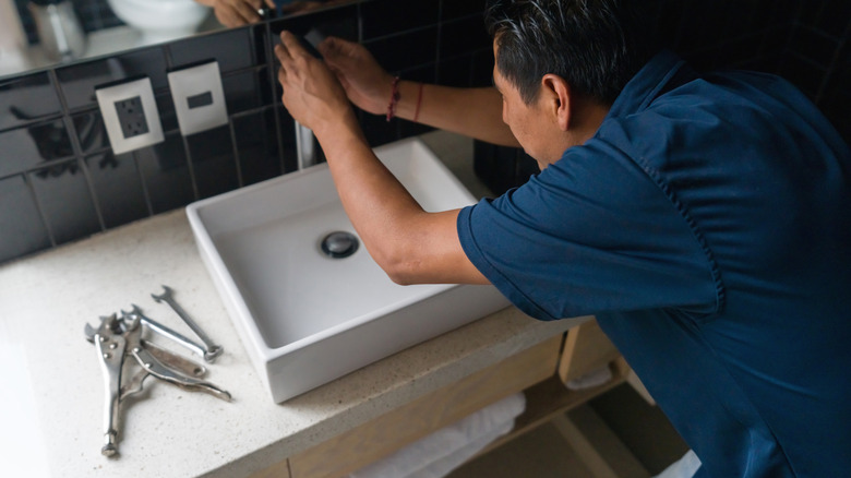 Person installing a new vanity and faucet