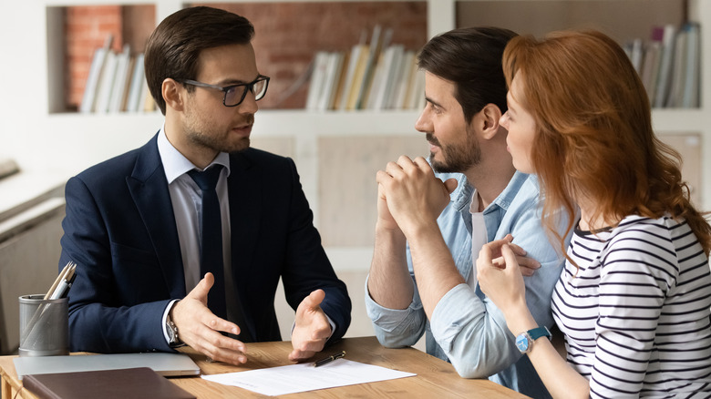 Person explaining finances to couple