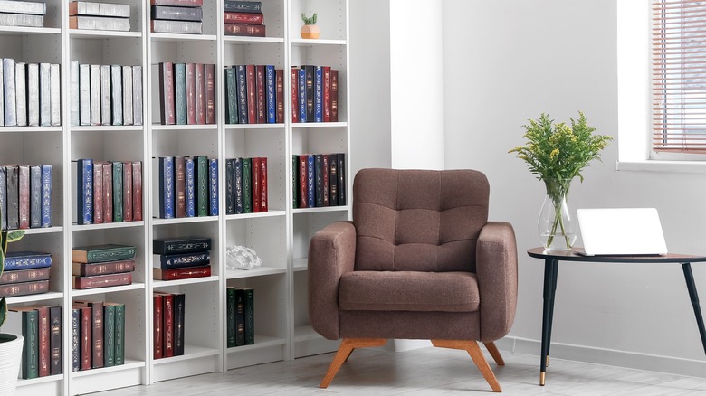 brown chair next to bookshelf