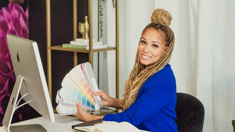 Breegan Jane posing at desk with paint colors