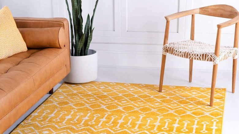 A room with a yellow rug