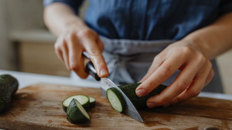 Person slicing cucumber