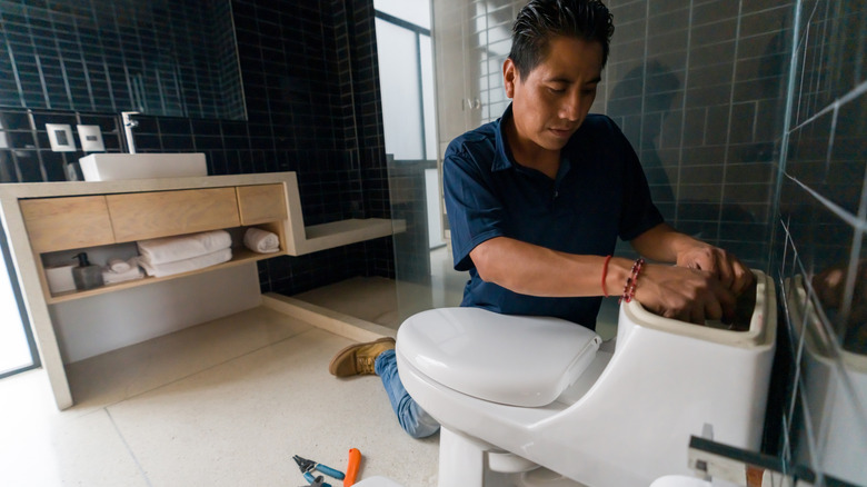 plumber installing toilet