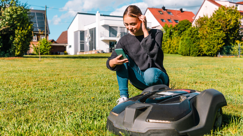 woman setting up robot mower