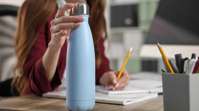 Woman holding a reusable water bottle