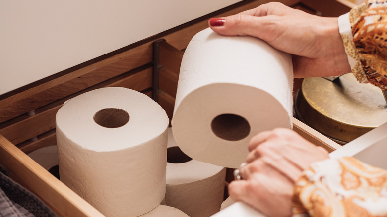 woman grabbing toilet paper roll