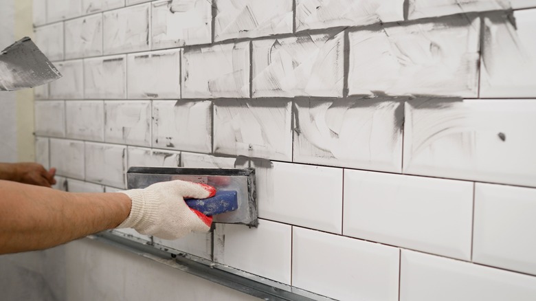 Person applying black grout