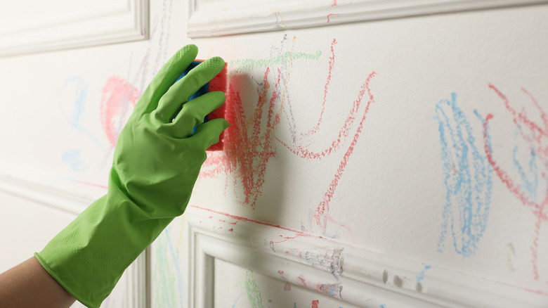 hand cleaning crayon on wall
