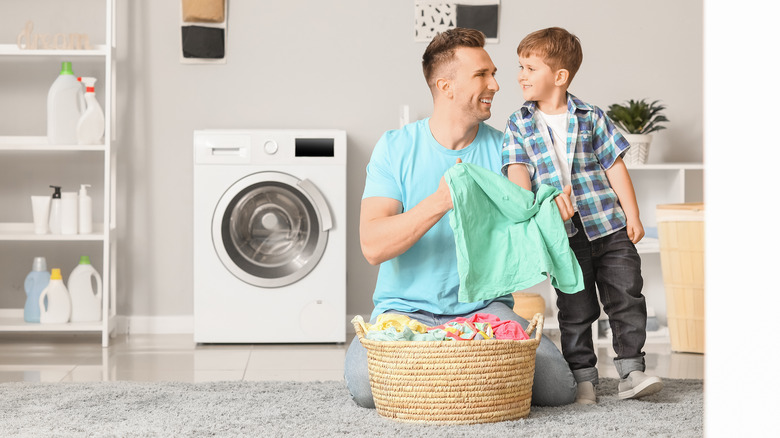Man showing laundry to child