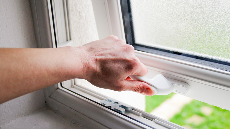 Hand opening a window outward