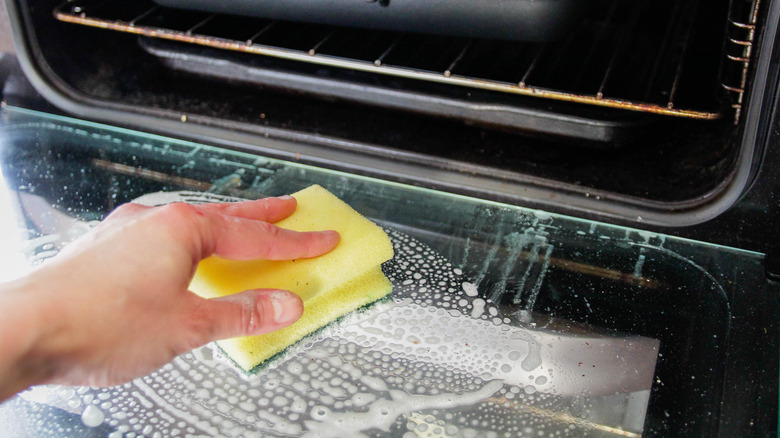 Person cleaning oven