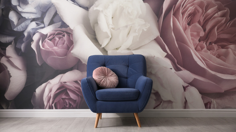 floral wallpaper behind blue chair