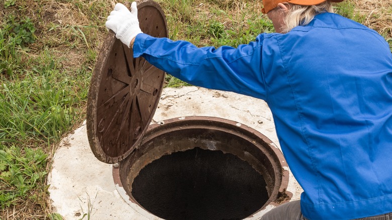 person looking into septic tank