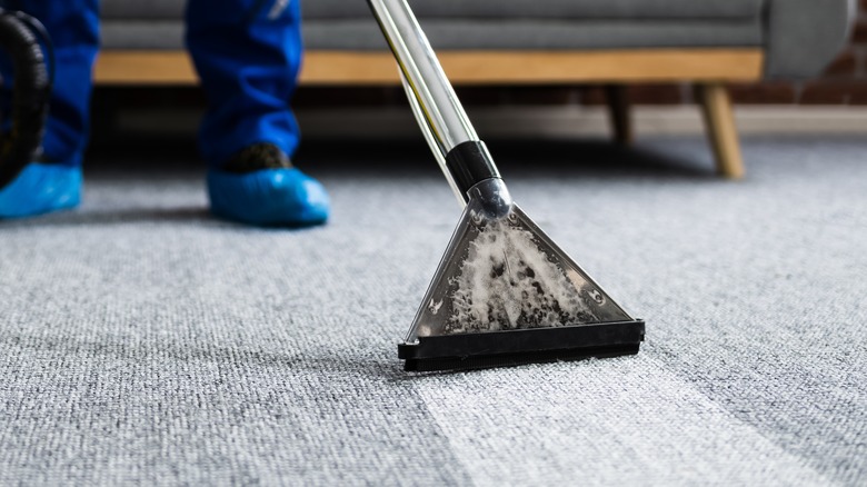 person shampooing carpet