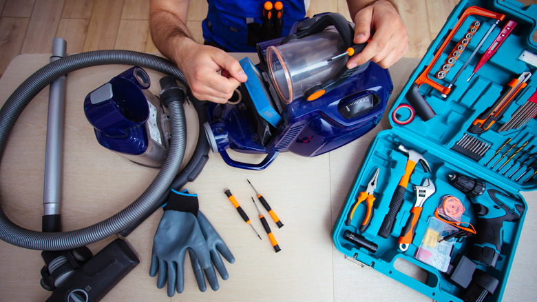 Man fixing broken vacuum 