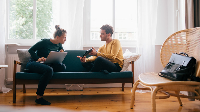 Couple with tablets on couch