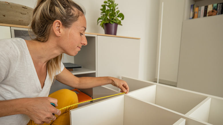 woman measuring closet unit