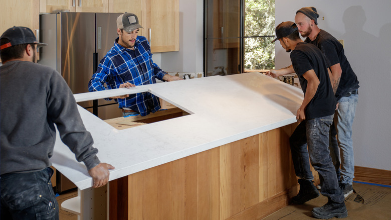 men installing white countertop