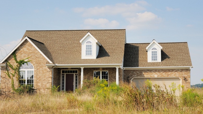 Abandoned house with overgrown landscape 