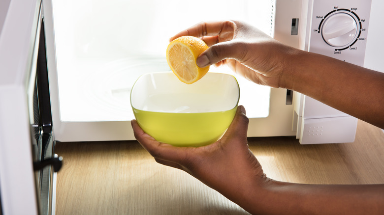 Hands holding lemon and bowl