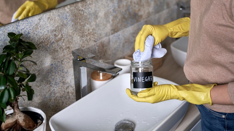 woman clean bathroom with vinegar