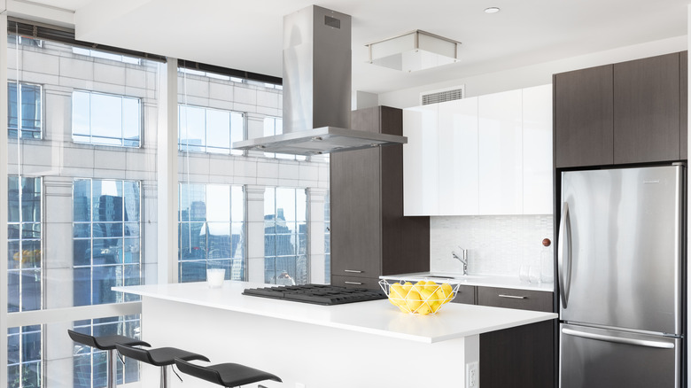 White kitchen island with cooktop and vent