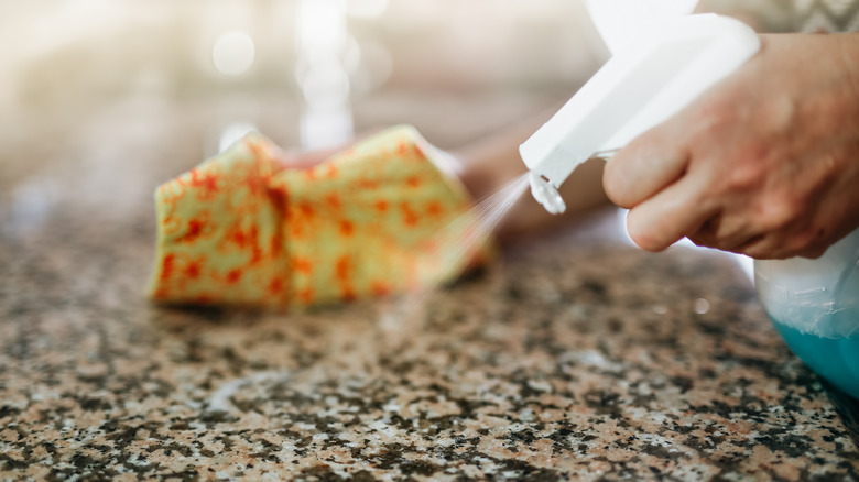 Spraying cleaning solution onto granite