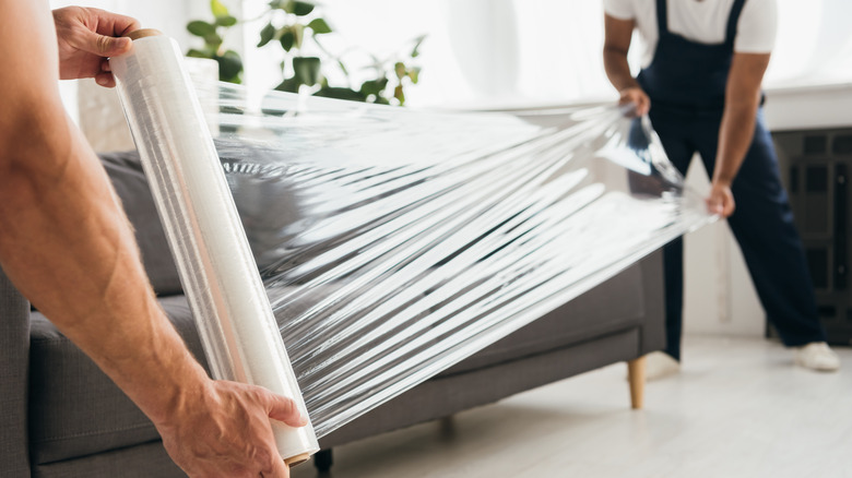 Movers wrap couch with plastic