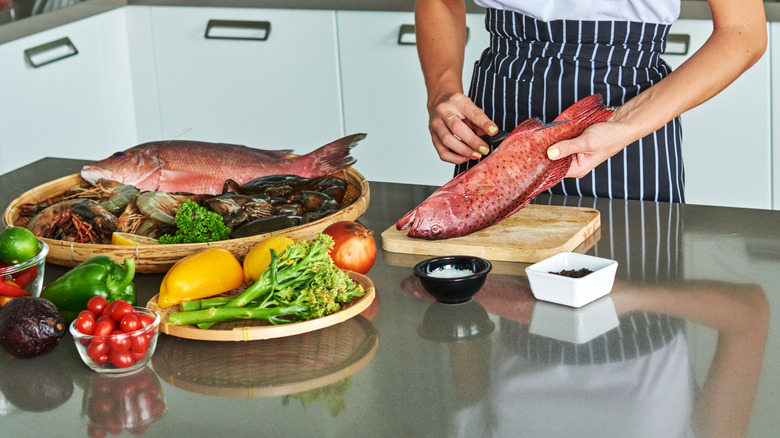 person preparing fish on kitchen counter