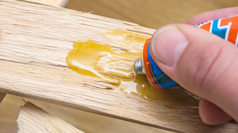 Person spreads glue onto wood