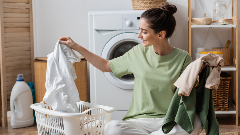 Woman holding laundry she removed from basket