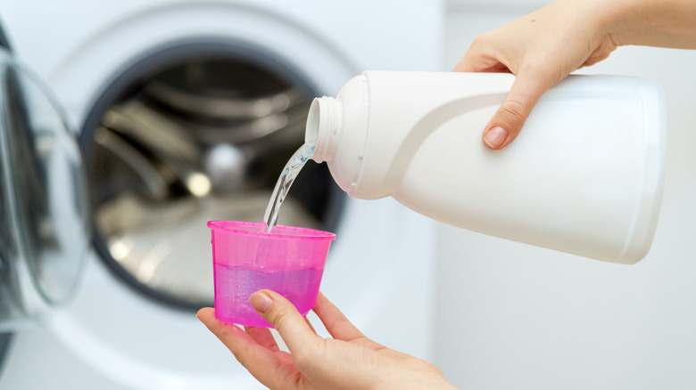 Pouring detergent into cup