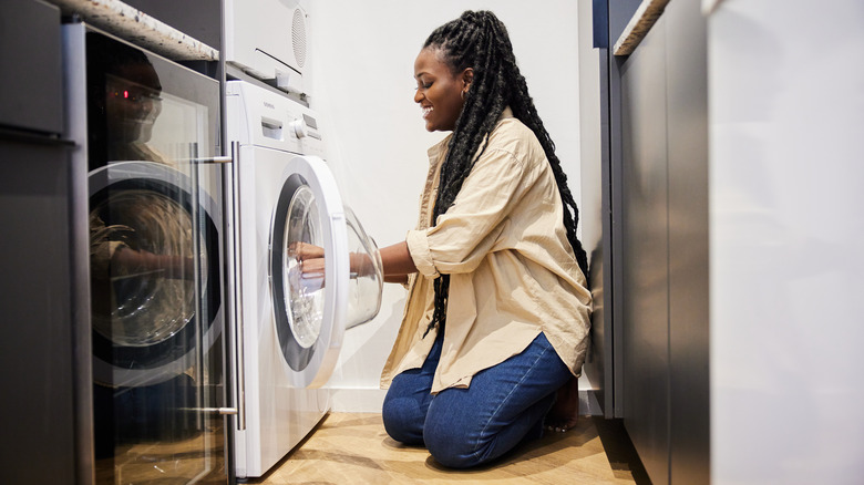 Woman loading washing machine