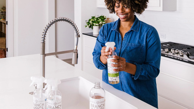 Woman refilling Branch Basics bottle 