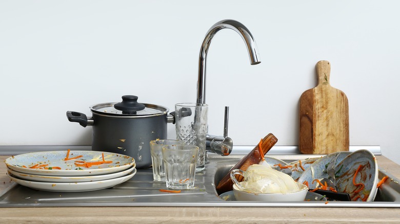 Dirty dishes piled up in the sink