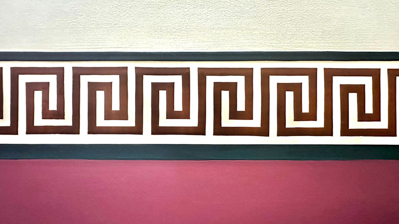 A Greek key pattern design breaking up a red and white wall