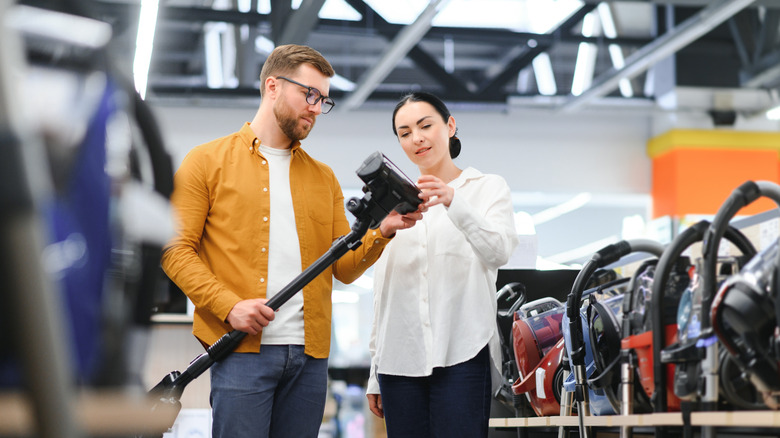 Couple shopping for vacuum cleaners