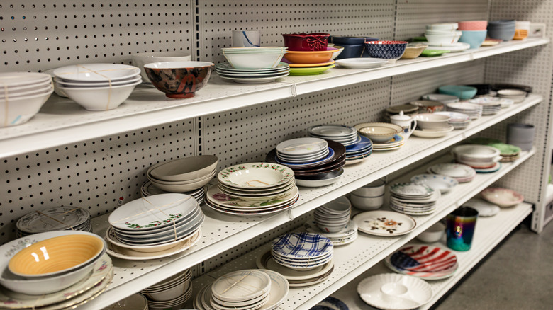 Thrift store shelves covered with various dishes and cookware