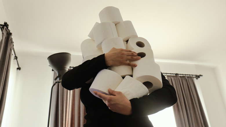 person holding white toilet paper 