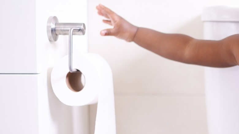 Child reaching for toilet paper