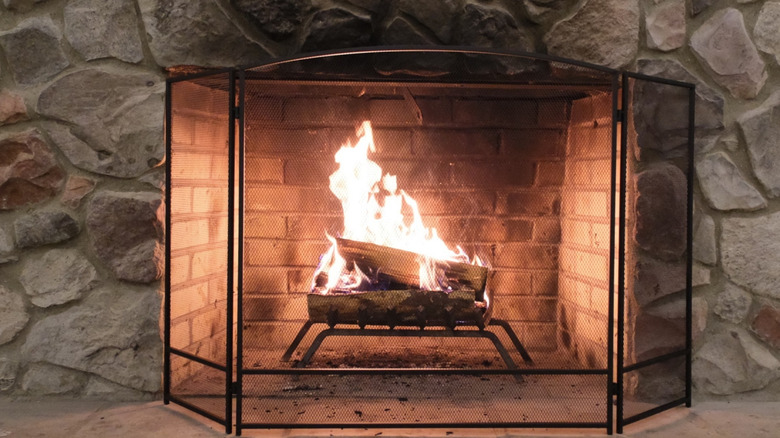 Stone fireplace with black metal screen