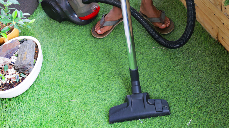 person cleaning artificial turf