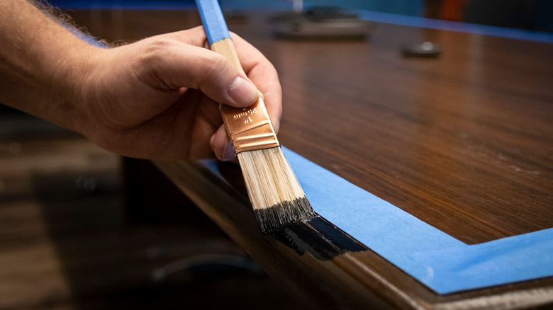 a person painting wood