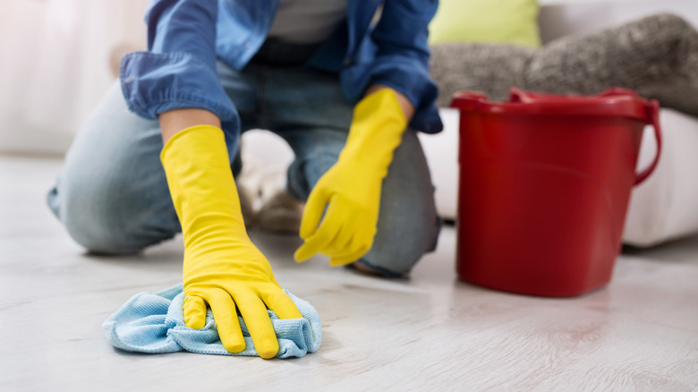 Woman scrubbing floor with rag