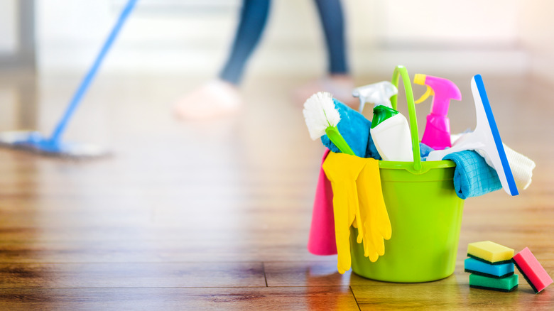 Cleaning items in bucket on wooden floor