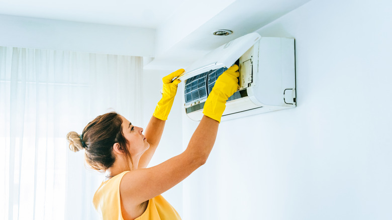 Woman checking air conditioner
