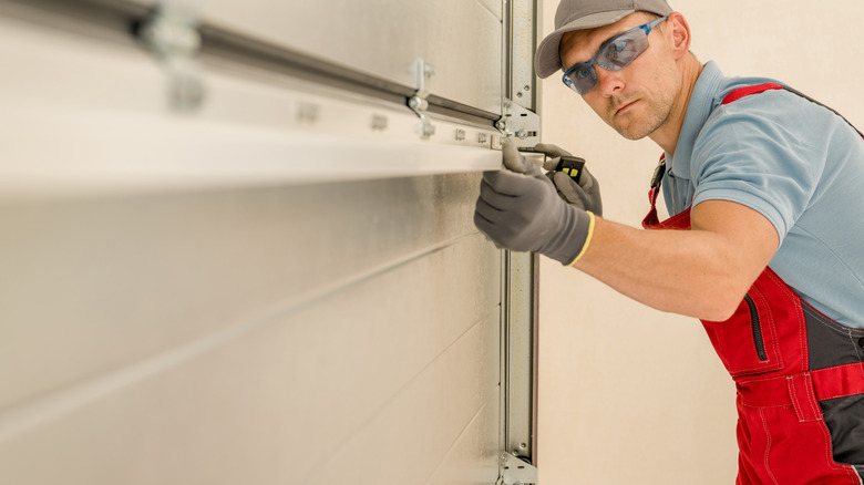 A man installing a garage door.